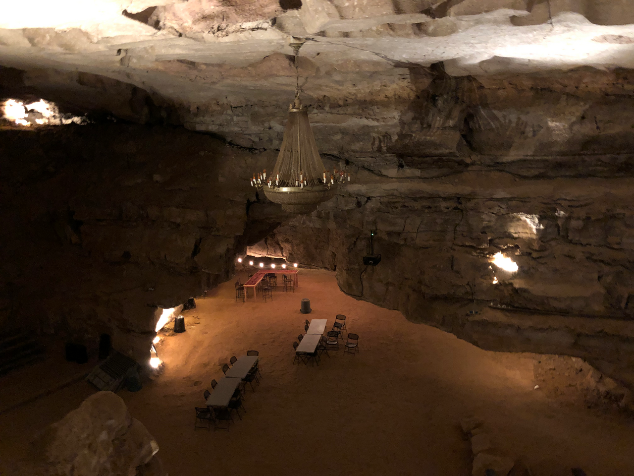 The real Volcano Room performance space inside Cumberland Caverns, with its chandelier, stage, tables and limestone walls